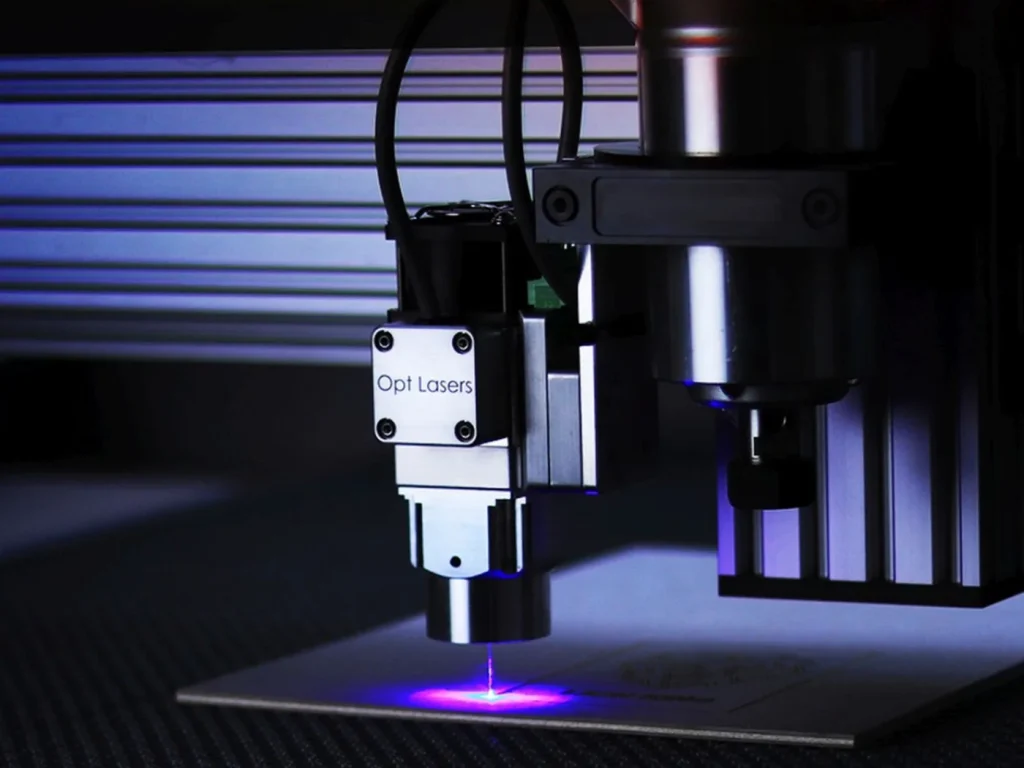 A laser cutting head cutting sheet material on a machine bed