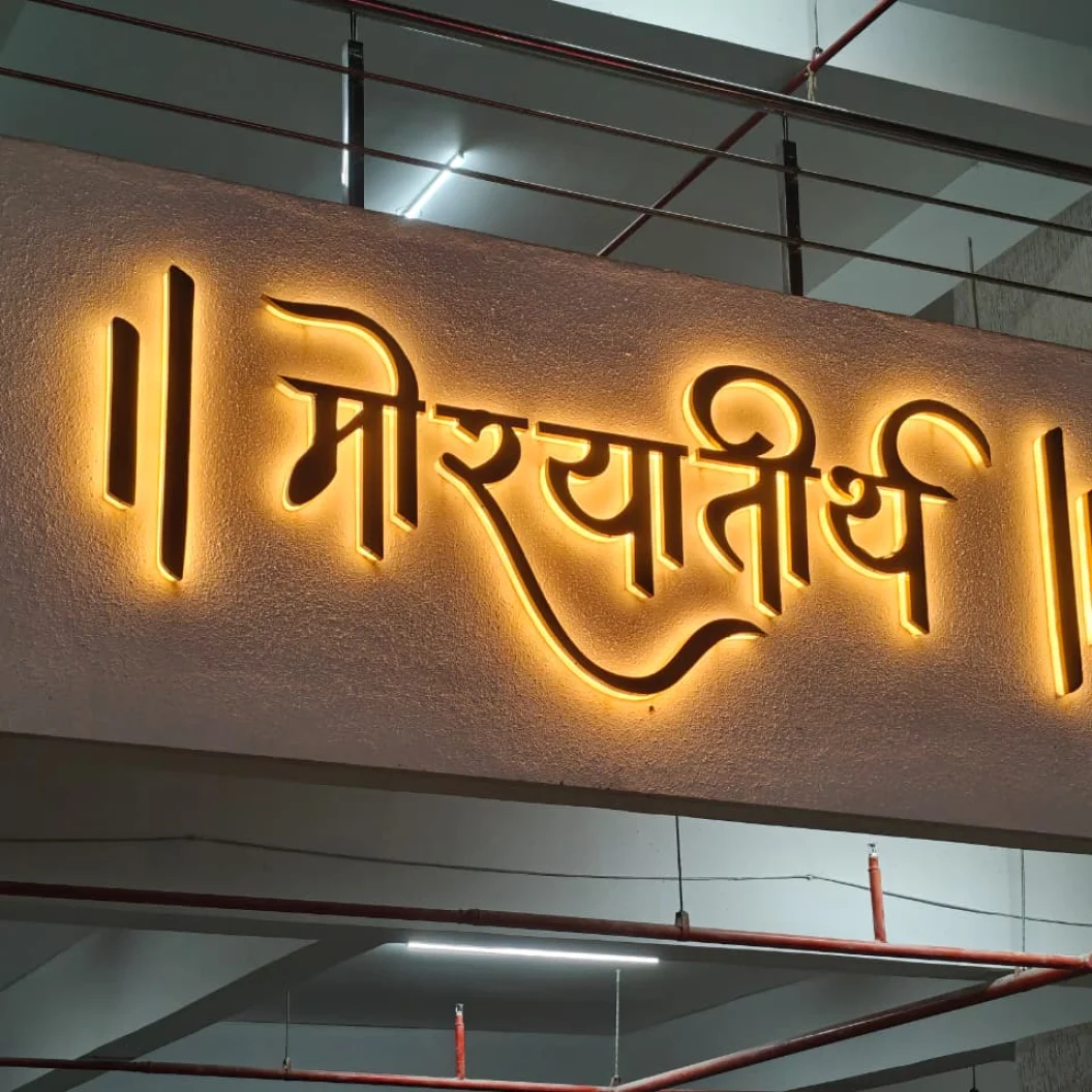 Backlit Devanagari lettering reading Morya Teerth on a building entrance, by ART CENTRRAL, Pune