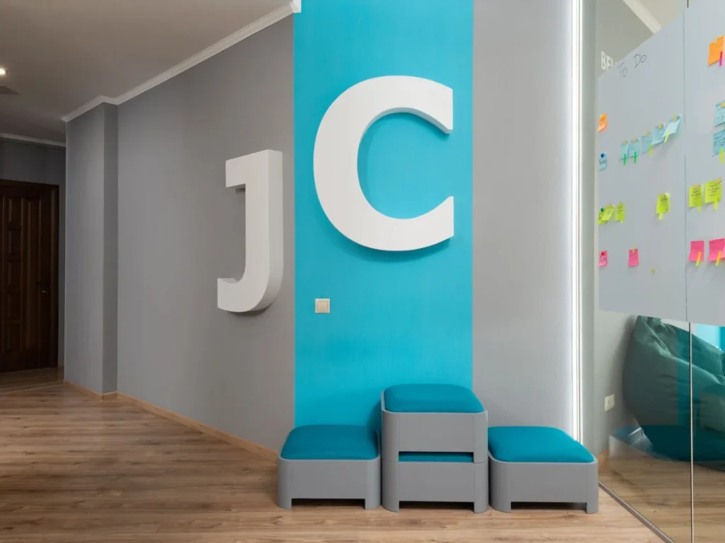 Large built-up letters mounted on a coloured wall in an office corridor